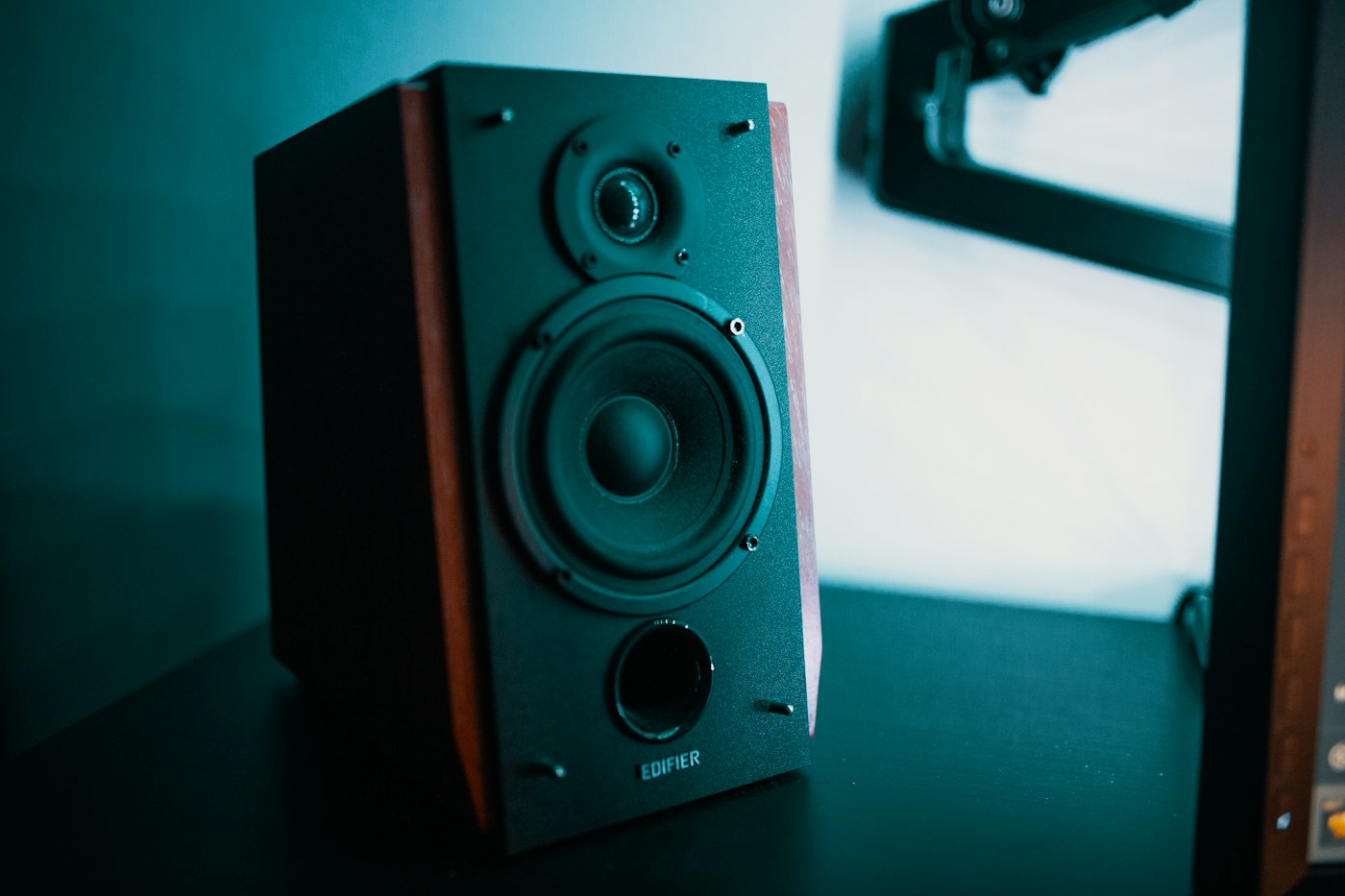 A bookshelf speaker beside a window in a listening room