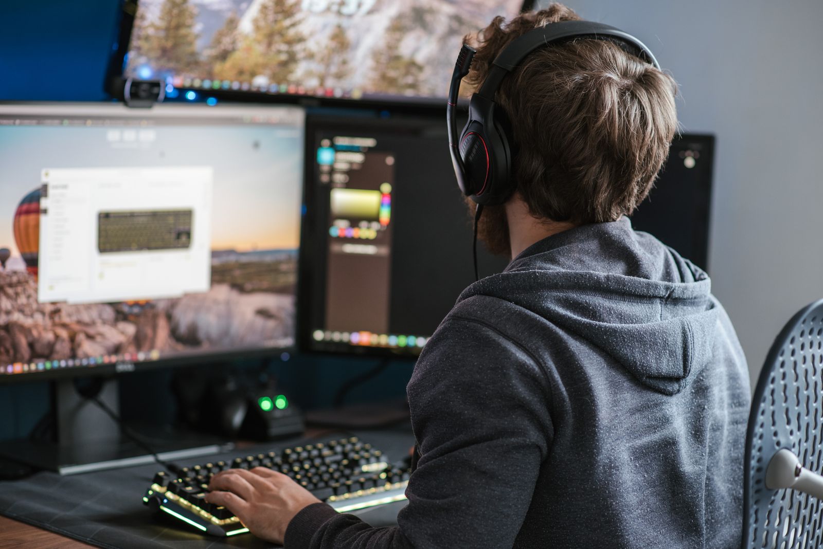 A person wearing a headset at a home gaming desk