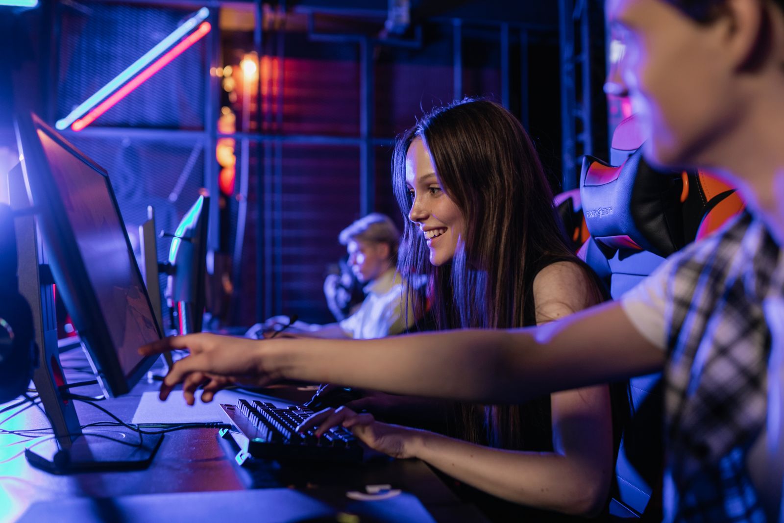 Two people playing games at a computer desk in a colorful room