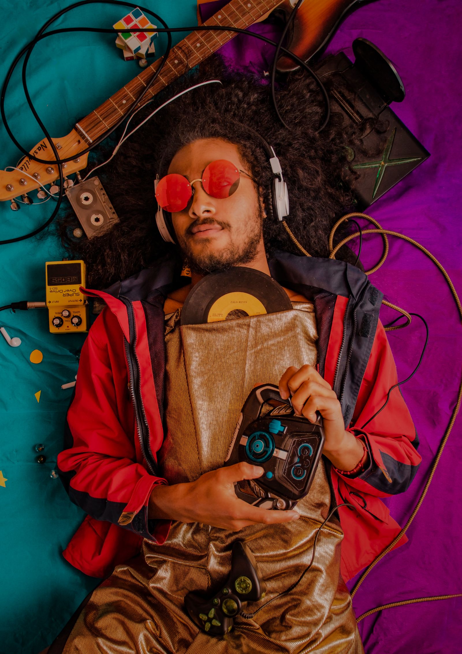 A man listening with headphones surrounded by records and audio equipment