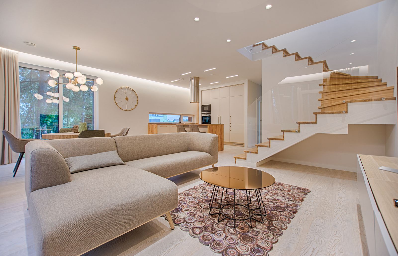An open living room with a sofa, staircase, and ceiling fixtures