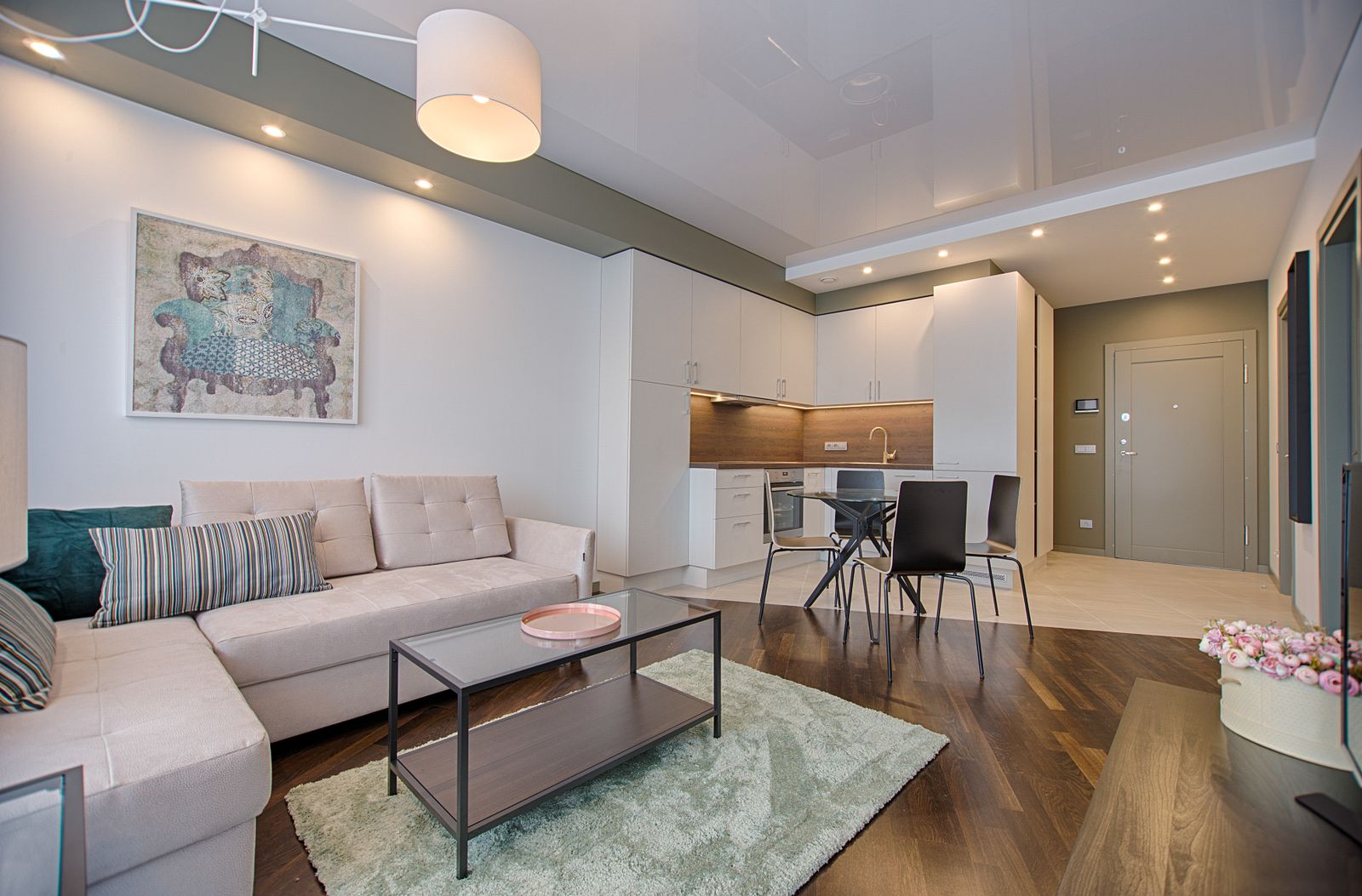 A furnished apartment living room with a sofa and an open dining area