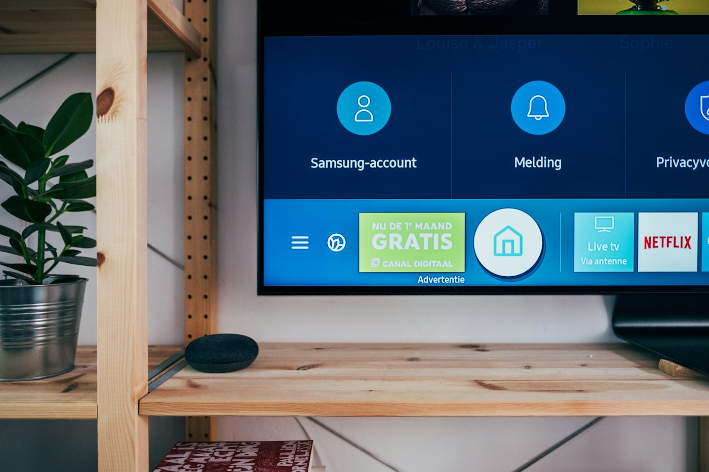 A television showing its app menu on a wooden media console